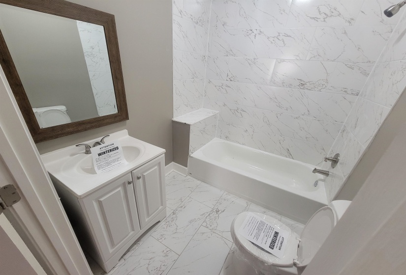 Full bathroom featuring vanity, light marble finish flooring, and tub / shower combination
