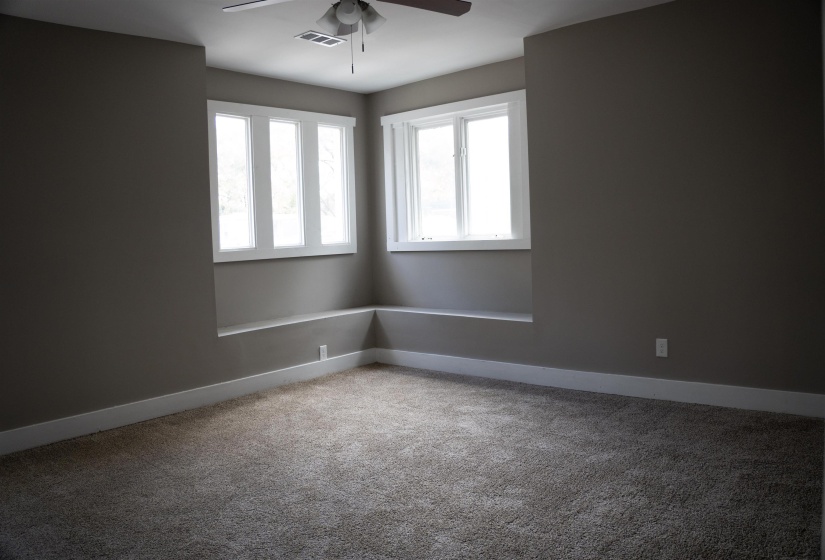 Spare room featuring light colored carpet and a ceiling fan