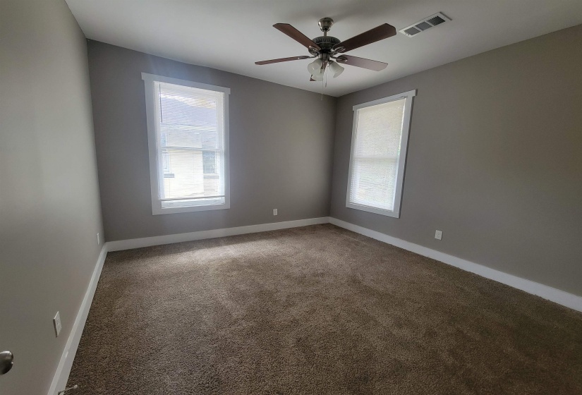 Carpeted empty room with baseboards and a ceiling fan