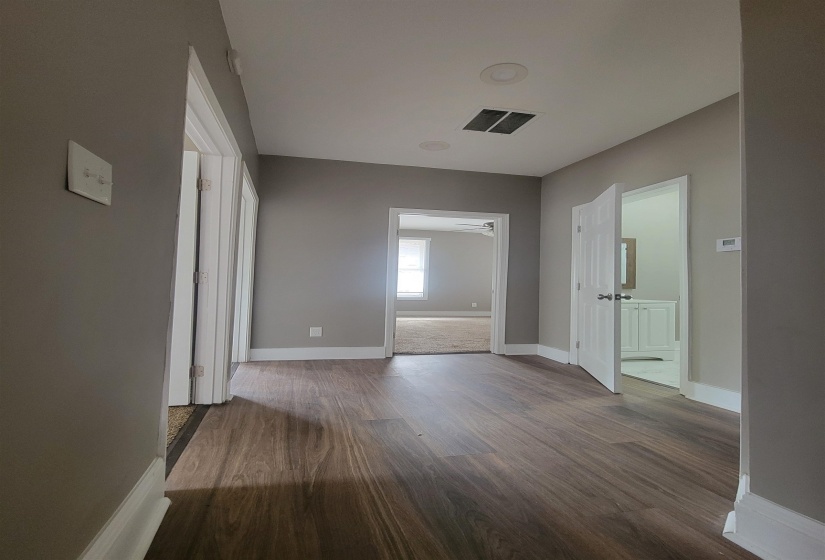 Corridor featuring dark wood-style floors and baseboards