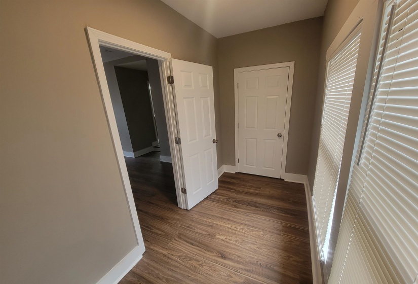Corridor featuring baseboards and dark wood finished floors