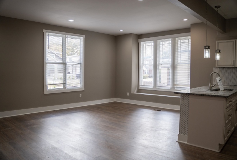 Unfurnished dining area with dark wood-style flooring and recessed lighting