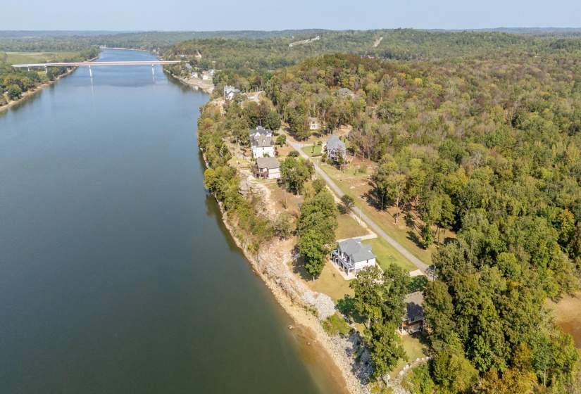 Aerial view of property and surrounding area with a nearby body of water and a forest