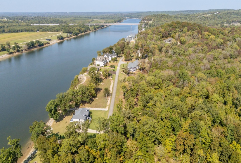 Drone / aerial view of a nearby body of water and a heavily wooded area