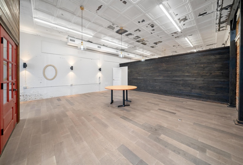 Empty room with wooden walls, an ornate ceiling, and wood finished floors
