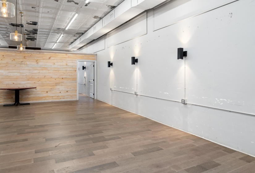 Empty room featuring wood finished floors, wooden walls, and an ornate ceiling