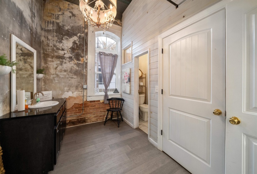 Hallway featuring wood finished floors and a chandelier