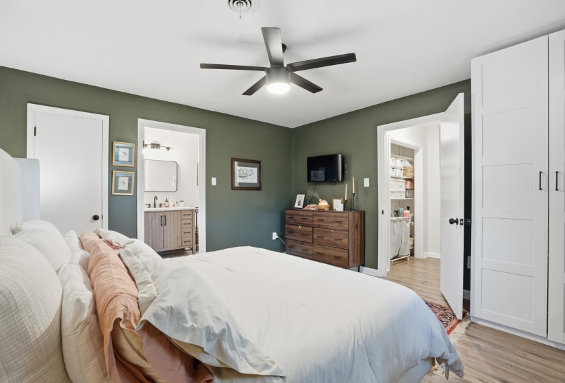 Bedroom featuring light wood-style flooring, ensuite bathroom, and a ceiling fan