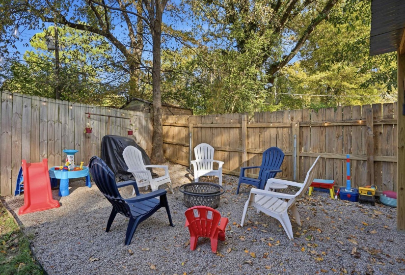 Fenced backyard featuring an outdoor fire pit and a patio