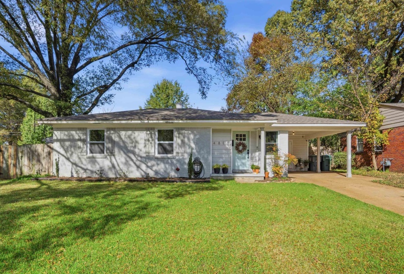 Ranch-style house featuring a porch, driveway, a carport, brick siding, and a shingled roof