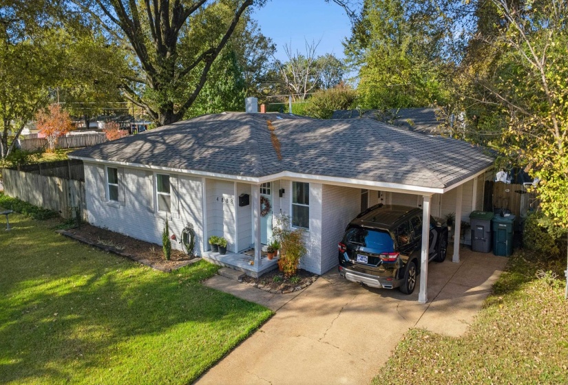 Ranch-style home with an attached carport, roof with shingles, and concrete driveway