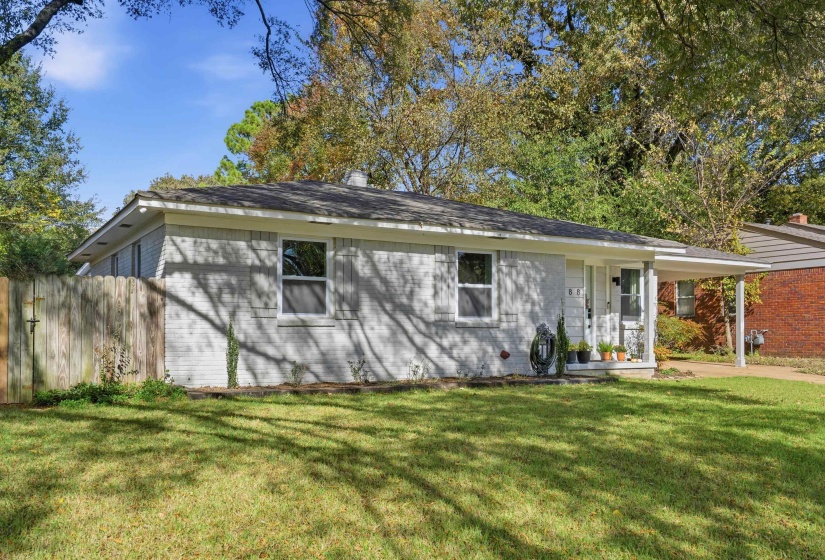 Single story home featuring a porch, a chimney, a shingled roof, and an attached carport