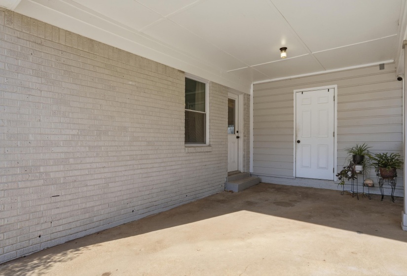 Entrance to property with a patio and brick siding