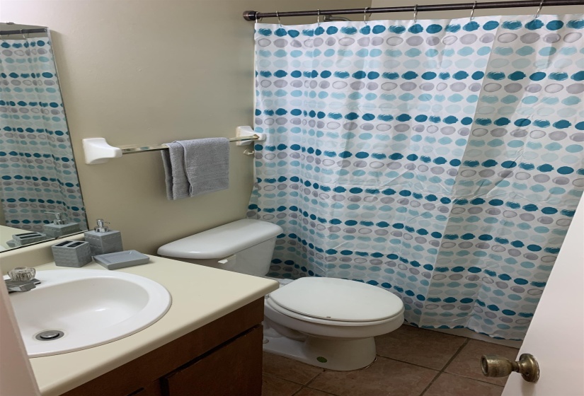 Bathroom featuring light tile patterned floors, vanity, and a shower with shower curtain