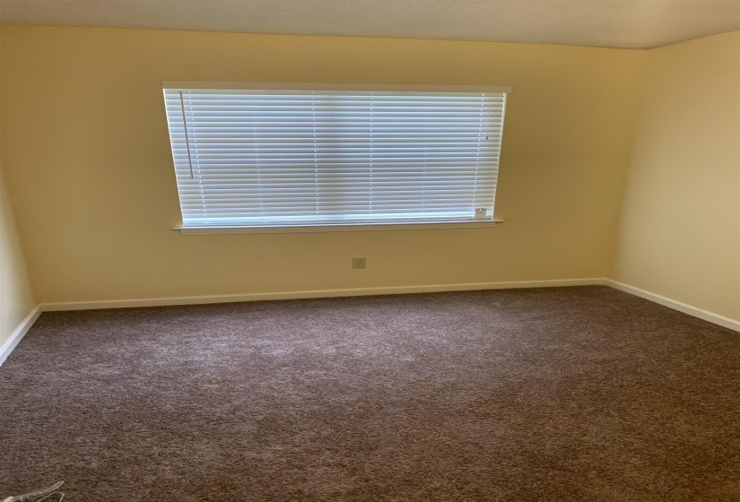 Unfurnished room with dark carpet and plenty of natural light