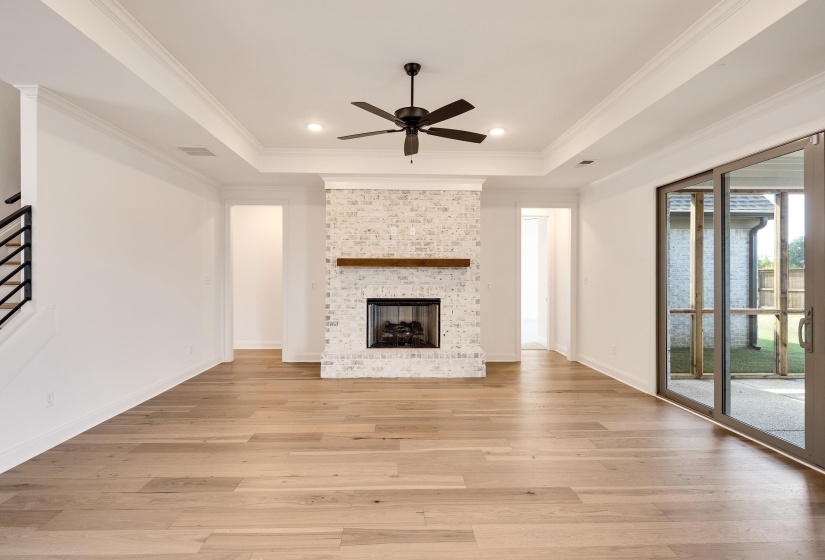 Another view of the den. Hardwood floors and ceiling fan.