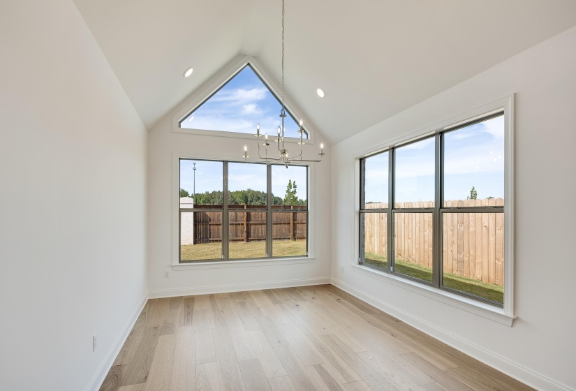 Gorgeous dining room with vaulted ceilings and cathedral style window!