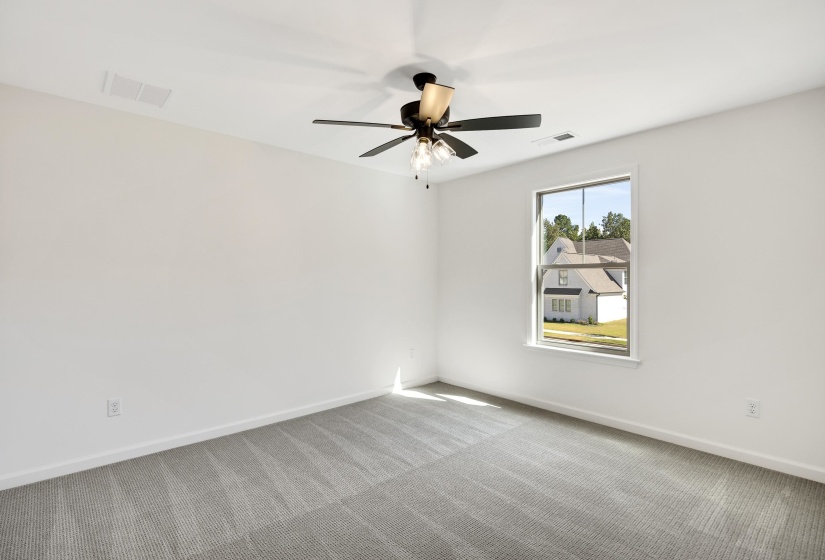 Bedroom 2 is downstairs with carpet and a ceiling fan.