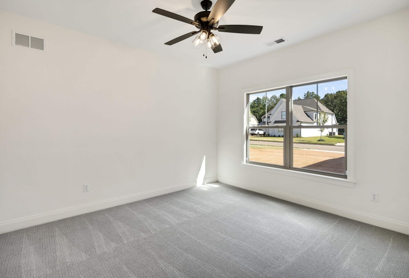 Large upstairs bedroom with carpet, ceiling fan and walk in closet.