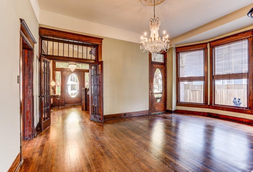 Entryway featuring hardwood / wood-style flooring, french doors, a chandelier, and ornamental molding