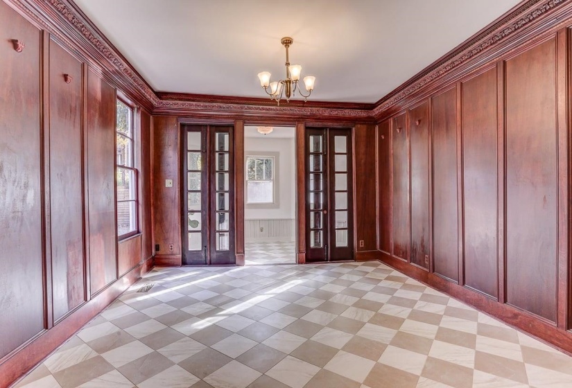 Entryway with crown molding, a chandelier, french doors, and wooden walls