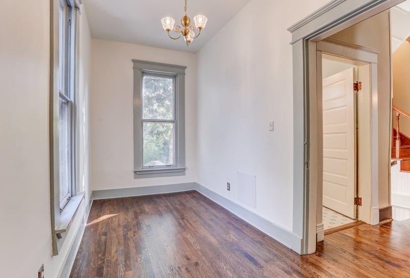 Spare room with dark wood-style floors and a chandelier