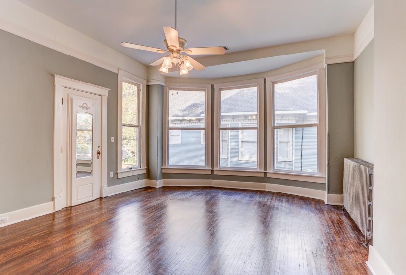 Spare room with radiator heating unit, dark wood-type flooring, and ceiling fan