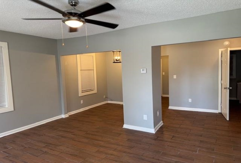 Unfurnished room featuring wood finished floors, a textured ceiling, baseboards, and ceiling fan