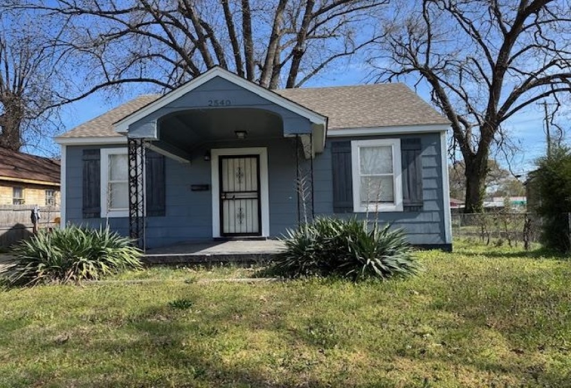 Bungalow-style house with covered porch, roof with shingles, fence, and a front lawn