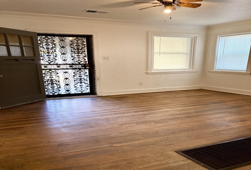 Spare room with plenty of natural light, dark wood-style floors, ornamental molding, and ceiling fan