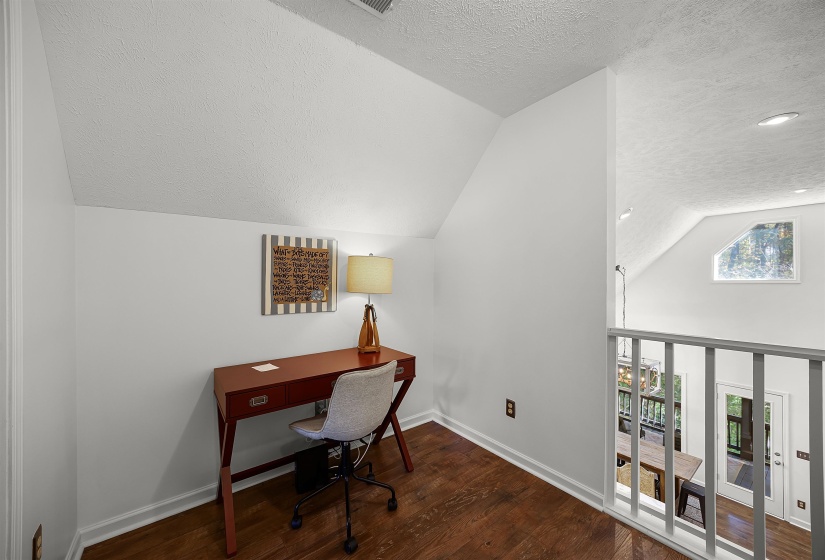 Home office with a textured ceiling, vaulted ceiling, dark wood-style flooring, and recessed lighting
