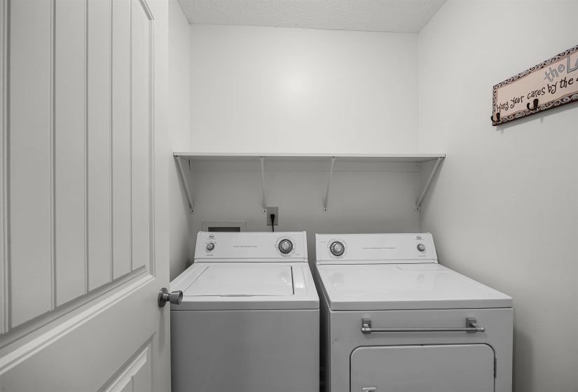 Laundry area with independent washer and dryer and a textured ceiling