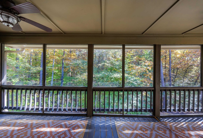 Unfurnished sunroom featuring plenty of natural light and view of wooded area