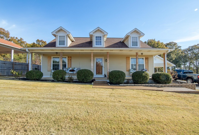View of front of home with covered porch and a shingled roof