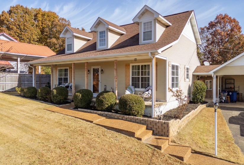 View of front of home with covered porch and roof with shingles