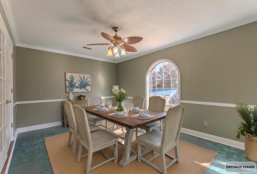 Dining area with crown molding, dark tile patterned flooring, and a ceiling fan