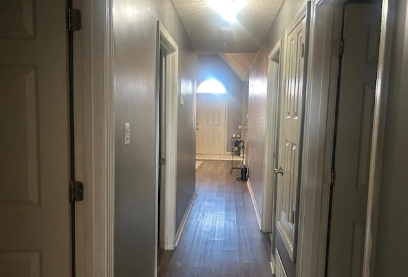 Hallway featuring dark wood finished floors and a textured ceiling