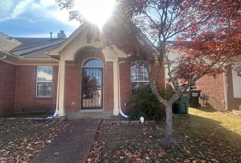 Property entrance featuring brick siding and a chimney