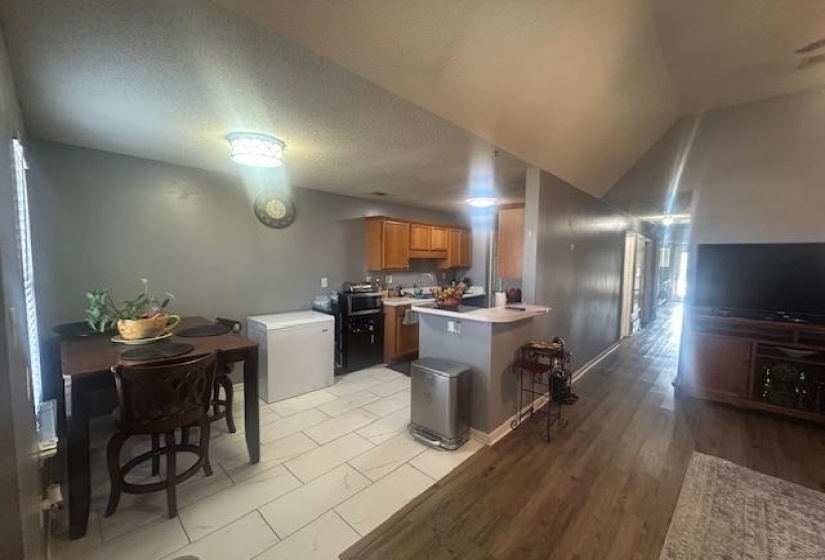 Kitchen featuring light countertops, brown cabinetry, a peninsula, a textured ceiling, and light wood finished floors
