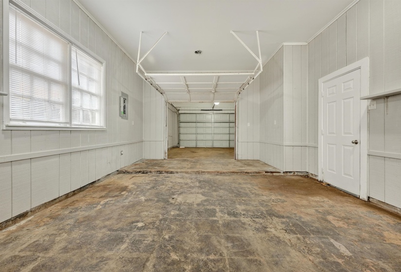 Garage featuring electric panel and wood walls