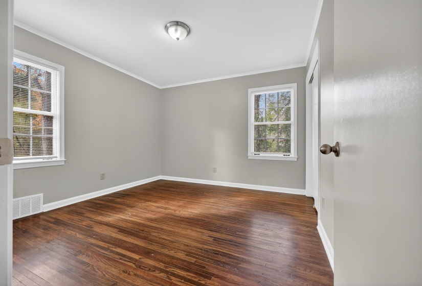 Unfurnished room with ornamental molding and dark wood-style flooring