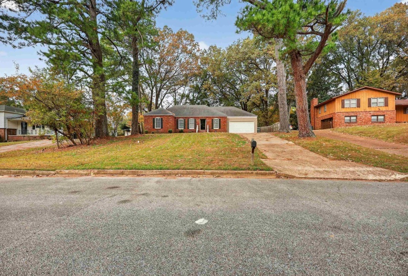View of front of home featuring a front lawn, driveway, and an attached garage