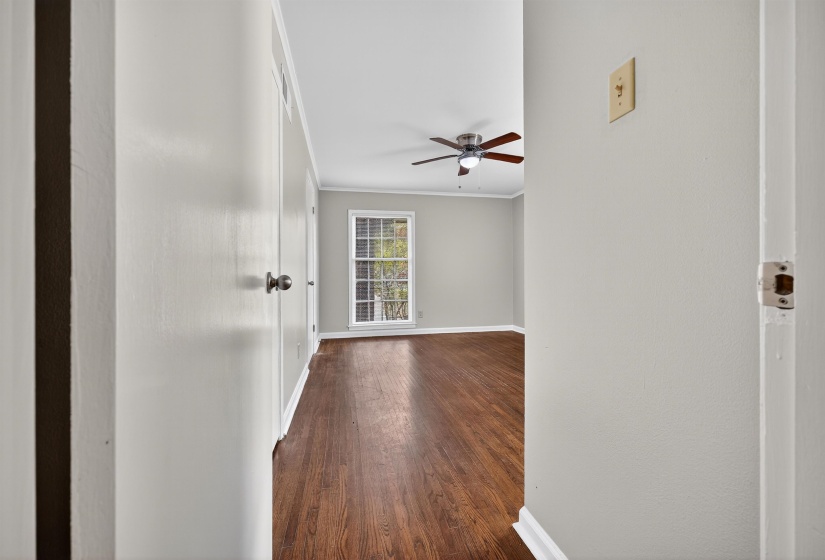 Unfurnished room with dark wood-type flooring, ornamental molding, and ceiling fan