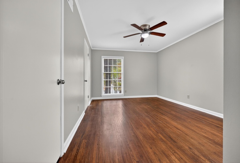 Unfurnished room featuring ornamental molding, dark wood-style floors, and a ceiling fan