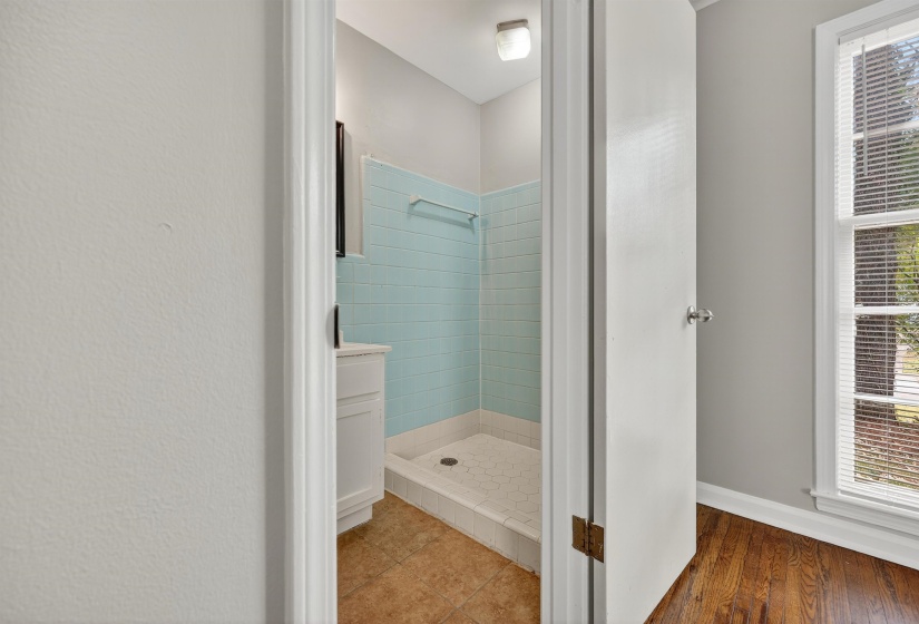 Bathroom with a shower stall and light wood finished floors
