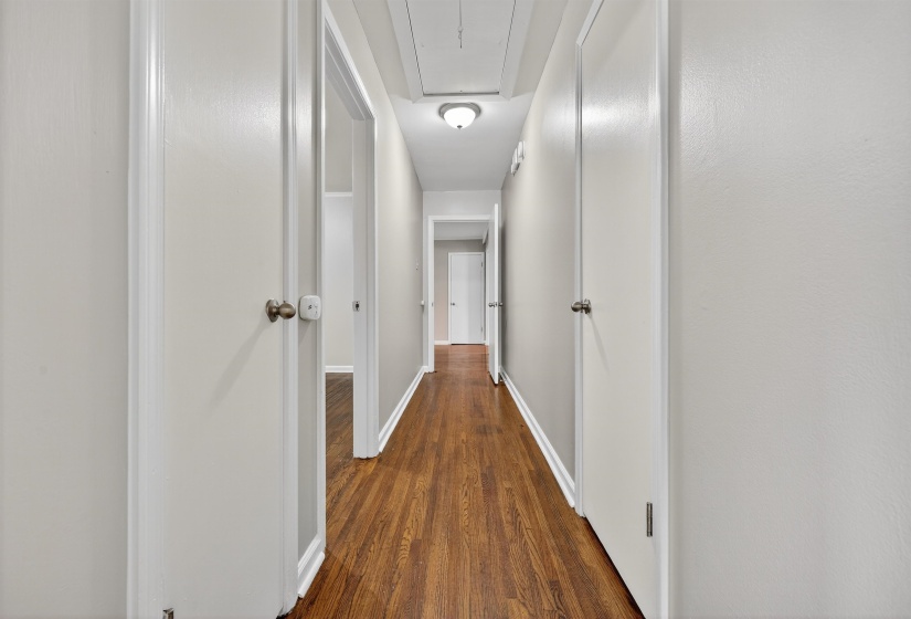 Hall with dark wood-type flooring and attic access