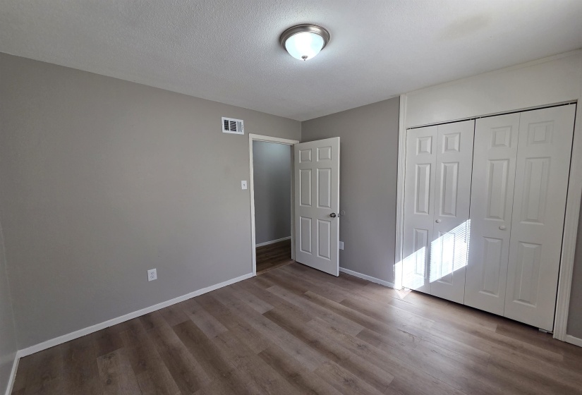 Unfurnished bedroom featuring light wood-style floors, a closet, and a textured ceiling
