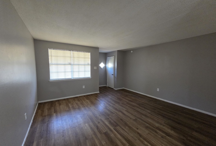 Spare room featuring dark wood-style flooring and a textured ceiling