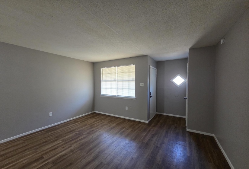 Entrance foyer featuring a textured ceiling and dark wood-style flooring