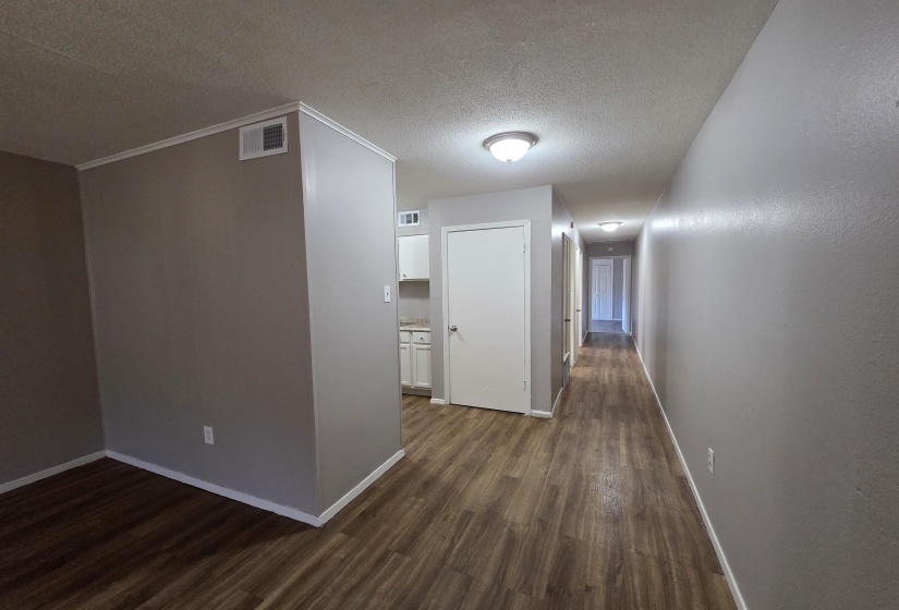 Corridor featuring dark wood-style flooring and a textured ceiling